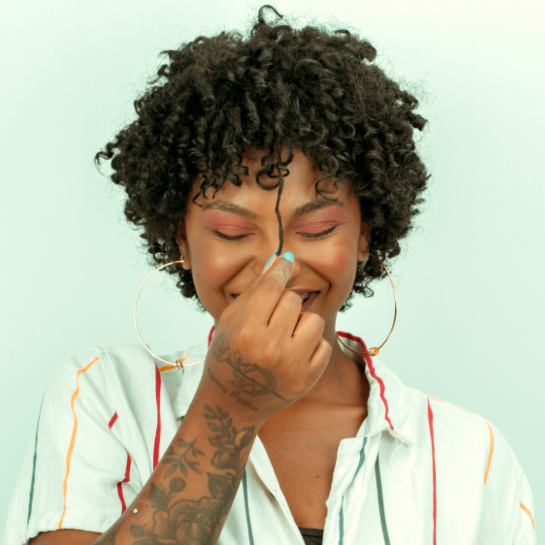 Black woman pulling on her curly, hydrated hair to show length