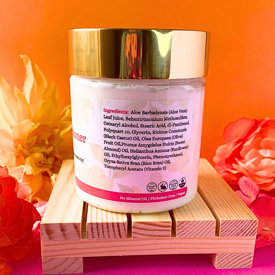 Side view of Curly Assembly Unscented Repairing Deep Conditioner jar listing natural ingredients like aloe vera, black castor oil, sweet almond oil, and vitamin E to restore damaged hair, strengthen strands, and lock in moisture without any added fragrance.