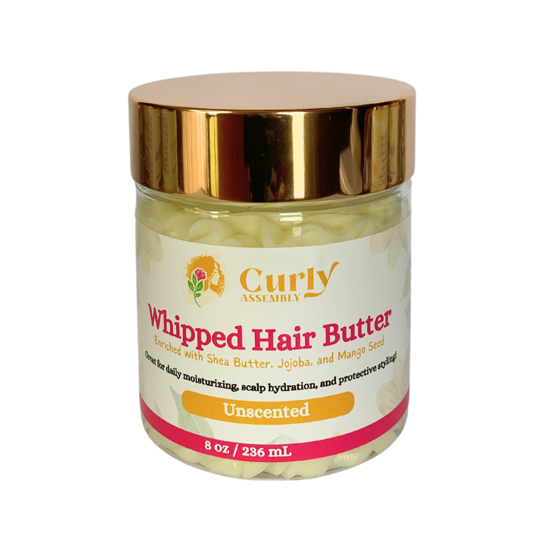 Front-facing jar of Curly Assembly Unscented Whipped Hair Butter posed with a floral background, providing a deeply moisturizing blend of shea butter, mango seed butter, and grape seed oil for curly hair without added fragrance, ideal for sensitive scalps.